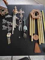 All six wind chimes and bird house displayed on table
