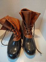 Front view of pair of brown leather and black rubber lace-up duck boots