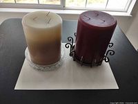 Front view of both candles with holders on surface