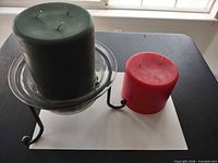 Green and red three-wick pillar candles and glass holder