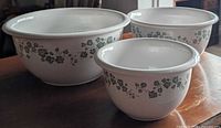 Three Corelle stoneware mixing bowls showing exterior green ivy vine pattern and nested graduated sizes
