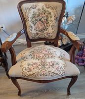 Front view showing full chair, wood carving, needlepoint designs