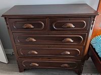 Front view of gumwood dresser showing five drawers and carved pulls