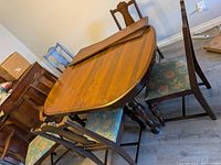 overall view of table with leaves placed on top and several chairs