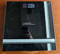 Top view showing Living Basics branding, glass surface, LCD display