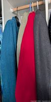 Four jackets hanging: teal, olive, red, grey