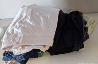 Stack of white, navy and khaki shorts on table