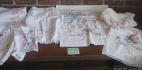 Group of embroidered linens spread on furniture