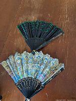 Both folding fans fully opened on tabletop