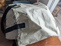Beige fabric bag containing rolled air mattress