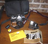 Full kit laid out: camera with lens, flash, bag, manual, accessories