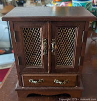 Front view of wood jewelry cabinet closed