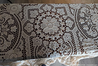 Full view of crocheted tablecloth laid out showing overall pattern