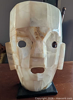Front view of translucent stone mask on base