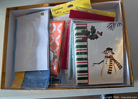 Box overview of assorted card packs and envelopes