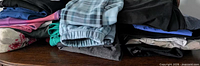 Stack of assorted pants, capris and shorts in various colors and fabrics