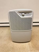 Front view of Simplicity DM28 dehumidifier showing grill and control knob