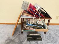 Overall lot on rolling cart showing binders, cork board, file folders box, paper punch