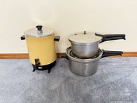 Pressure cookers and coffee urn grouped together