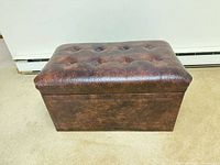Closed ottoman front view showing tufted top and embossed front panel