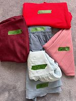 Overview of six folded tablecloths with size labels visible