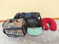 All four items grouped: duffel, tapestry tote, mint purse, neck pillow