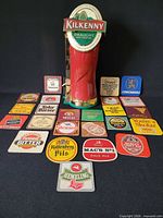 Front view of Kilkenny beer font with 25 coasters laid out