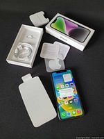 Full lot: iPhone 16 front view with accessories and box