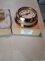 Clock on cardboard insert next to original box
