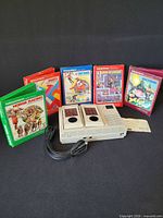 Console front with attached controllers and five boxed games