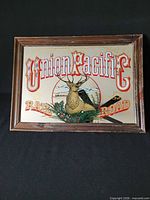 Front view of framed Union Pacific carnival glass mirror sign on black backdrop
