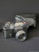 Front three-quarter view of camera with lens and case