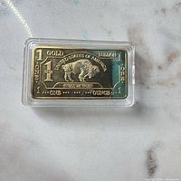 Obverse of bar showing buffalo motif, denomination markings, in capsule