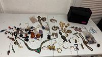 Full lot overview on tabletop showing all jewelry pieces and stones