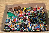 Box filled with loose LEGO parts, animals visible