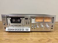 Front view of Alpage FL-6000 cassette deck with cassette loaded, showing controls and VU meters