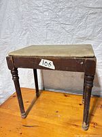 Three-quarter view of stool showing seat, legs, wear