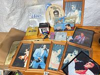 Group shot showing framed photos, plate, CDs, tin, figurine, mug, books
