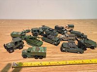 Group shot of all military vehicles on table with ruler for scale