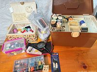 Overall lot view showing sewing basket, brown organizer, plastic boxes, magnifier and tools
