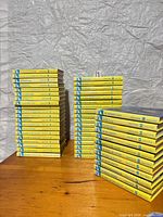 Three stacks of yellow Nancy Drew hardcover books displayed on table