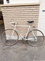 Full left side view of Raleigh white/blue road bicycle showing frame size, wheels, drivetrain