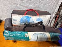 Both carry bags showing tent and screen house