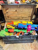 Open trunk filled with assorted Nerf blasters, rockets and other toys