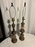 Two brass table lamps side by side on table, showing overall form and height