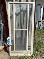 Front view of beige side of storm door leaning against wall