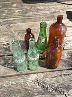 Group shot showing all eight bottles standing on wooden surface