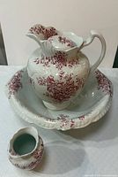 Pitcher inside basin with creamer in front displaying pattern and form
