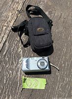 Front view of Canon PowerShot A430 camera beside black carrying case