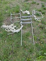 Two boat ladders and rope coils laid out on grass